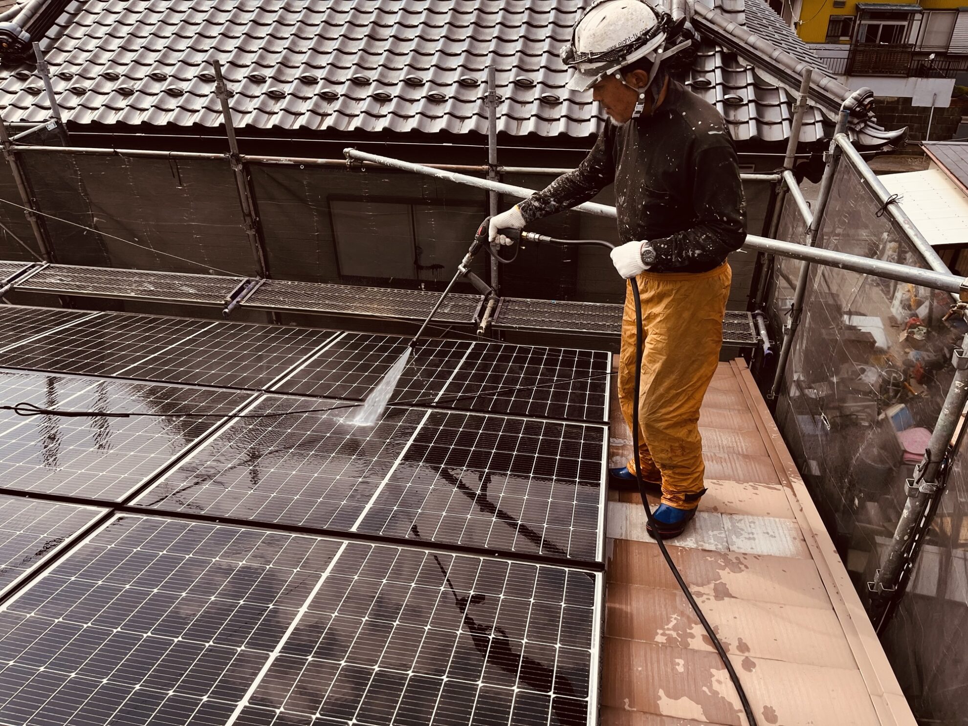 富里市K様邸で太陽光パネルを高圧洗浄している様子
