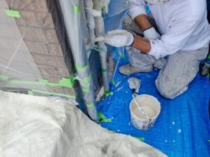 住宅の外壁塗装作業をしている職人の手